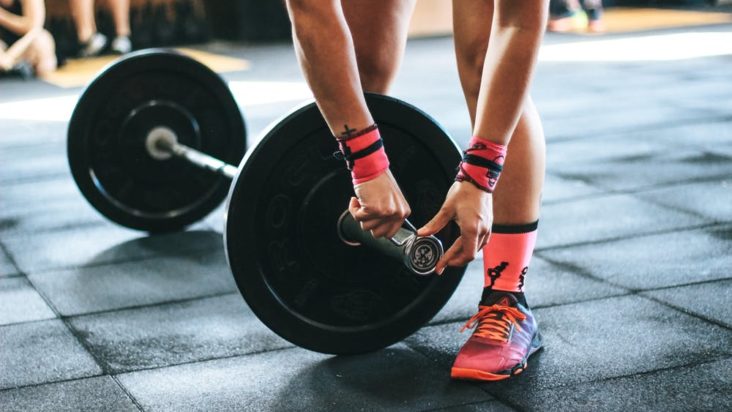 A photo of a person adjusting some weights