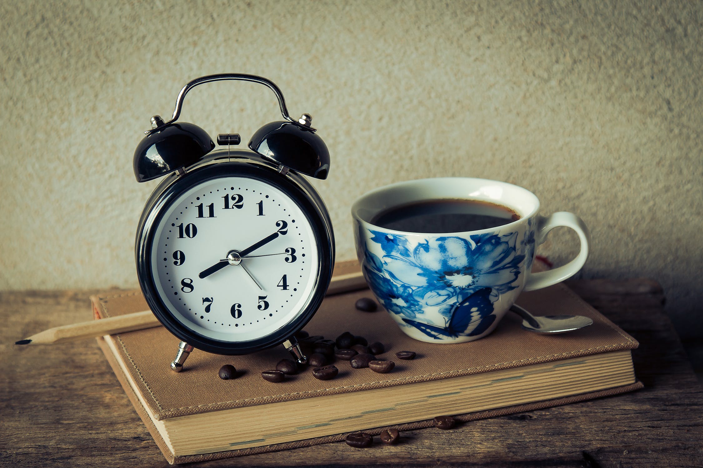 A photo of an alarm clock and a cup of coffee